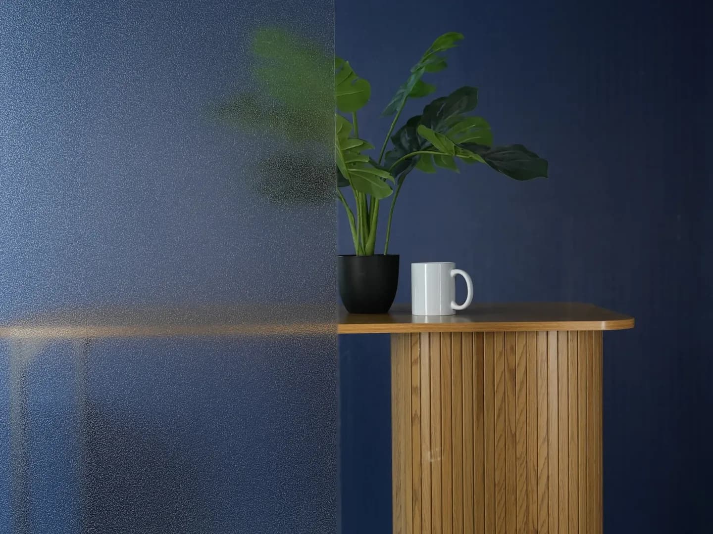 Film électrostatique granité posé sur un vitrage avec la silhouette d'une plante floutée